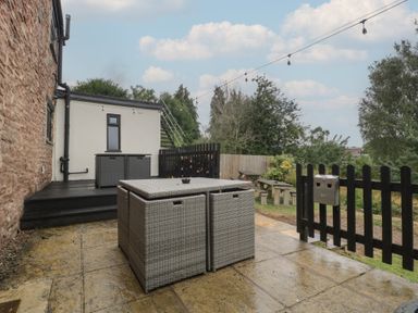 A garden with a patio table and storage boxes at Penny Farthing Inn Aston Crews near Ross-On-Wye