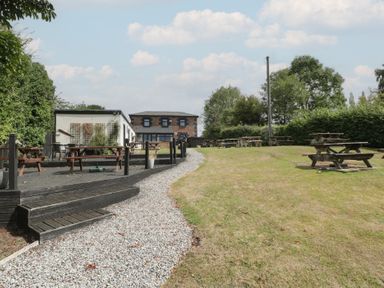 An outdoor area with tables and a pathway at Penny Farthing Inn Aston Crews near Ross-On-Wye