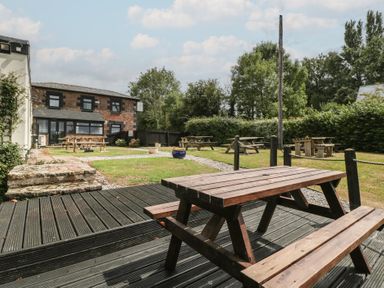 An outdoor seating area with tables and grass at Penny Farthing Inn Aston Crews near Ross-On-Wye