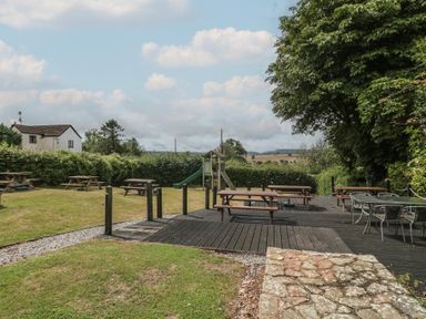An outdoor area with tables and benches at Penny Farthing Inn Aston Crews near Ross-On-Wye