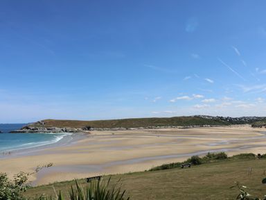 A beach with sand and ocean at Byron’s Retreat in Crantock