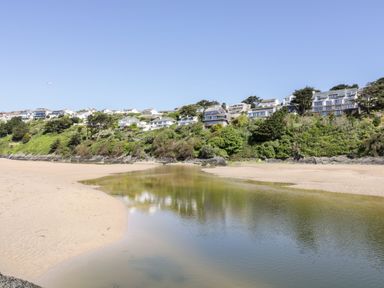 A beach with houses on a hillside at Byron’s Retreat in Crantock