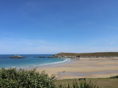 A beach with sand and water in the background at Byron’s Retreat in Crantock