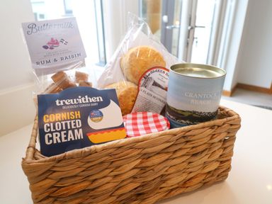 A basket with various food items including fudge and clotted cream at Byron’s Retreat Crantock