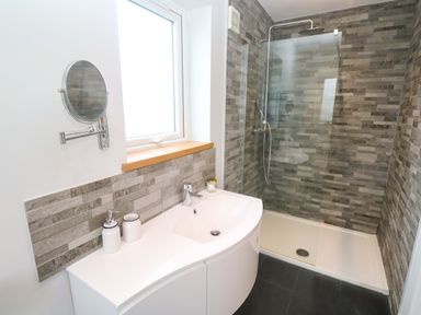 A bathroom with a shower and sink at Byron’s Retreat in Crantock