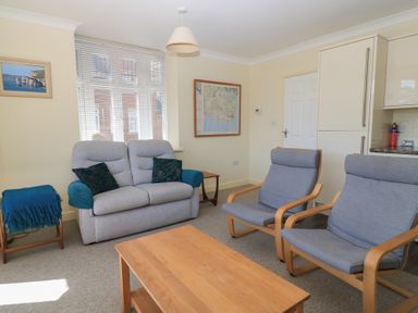 A living room with a sofa and two armchairs at Purbeck Vista in Swanage