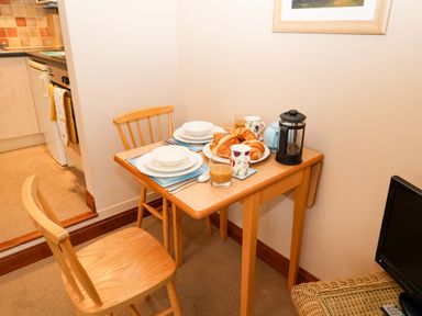 A kitchen table with a breakfast setup at Hayloft in Ipswich