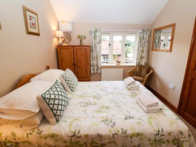 A bedroom with a bed and wardrobe at Hayloft in Ipswich