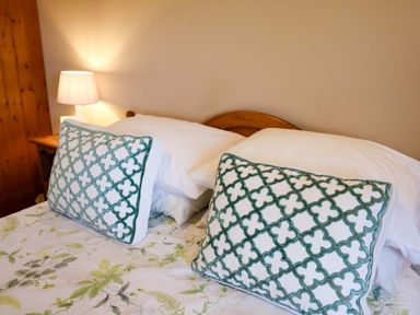 A bedroom with pillows and a lamp at Hayloft in Ipswich