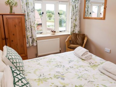 A bedroom with a bed and wardrobe at Hayloft in Ipswich