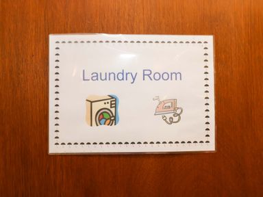 A laundry room sign on a wooden surface at Hayloft in Ipswich