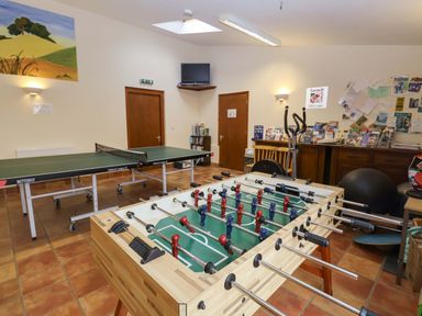 A game room with table tennis tables and a foosball table at Hayloft in Ipswich