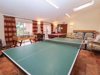 A games room with a table tennis table and a foosball table at Hayloft in Ipswich