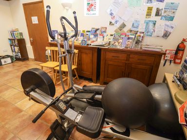 A gym with an elliptical trainer and exercise equipment at Hayloft in Ipswich