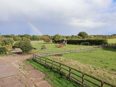 A playground and picnic area with a rainbow at Hayloft in Ipswich