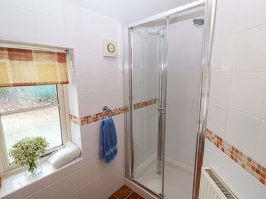 A bathroom with a shower stall and a window at Hayloft in Ipswich
