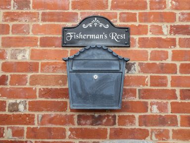 A mailbox and nameplate on a brick wall at Fisherman's Rest in Ipswich
