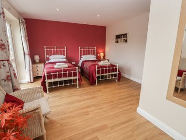 A bedroom with two beds and a chair at Fisherman's Rest in Ipswich