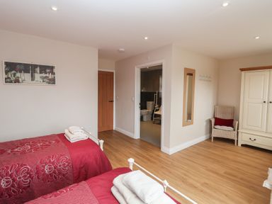 A bedroom with two beds and a chair at Fisherman's Rest in Ipswich