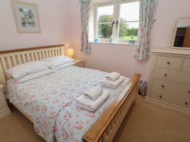 A bedroom with a double bed and dresser at Fisherman's Rest in Ipswich