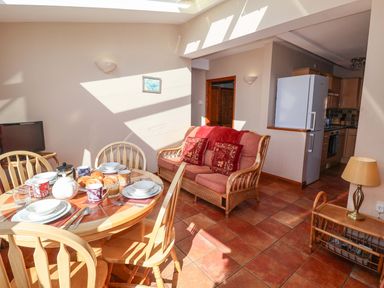 A dining room with a table and chairs at Coachman's Cottage in Ipswich