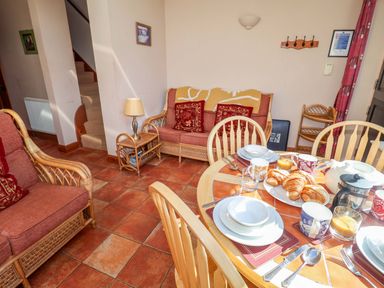 A dining room with a table and chairs at Coachman's Cottage in Ipswich