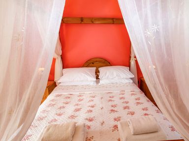 A bed with pillows and towels in a bedroom at Coachman's Cottage, Ipswich