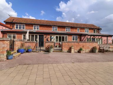 A building with a front porch and planters at Coachman's Cottage in Ipswich