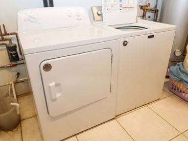 A washing machine and dryer in a laundry room at Coachman's Cottage, Ipswich
