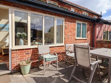 An outdoor seating area with chairs and a table at Churn House Ipswich