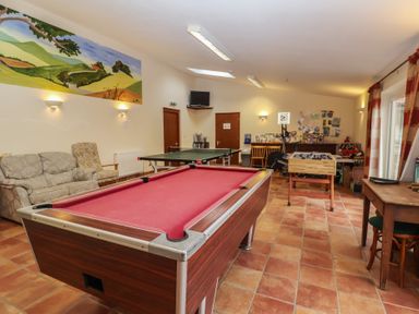 A game room with a pool table and ping pong table at Blacksmith's Cottage in Ipswich