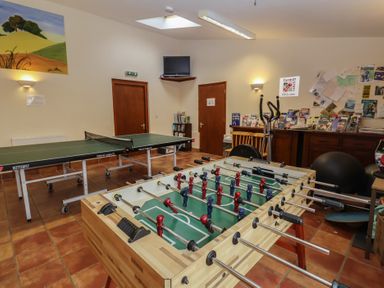 A recreation room with foosball and ping pong tables at Blacksmith's Cottage in Ipswich