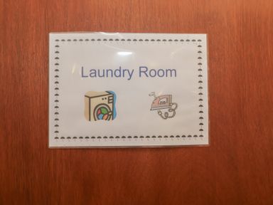 A sign indicating Laundry Room with icons at Blacksmith's Cottage in Ipswich