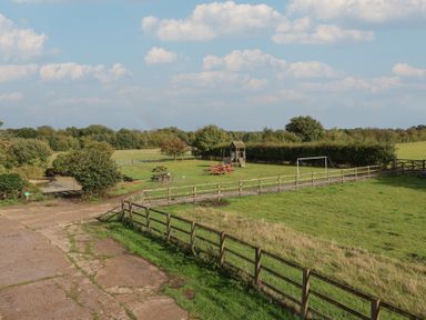 An outdoor area with a playground and picnic table at Blacksmith's Cottage in Ipswich