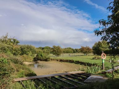 A water body with a bridge and surrounding trees at Blacksmith's Cottage Ipswich