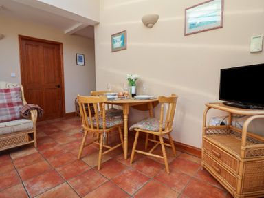 A dining room with a table and chairs at Wheelwright's Cottage in Ipswich
