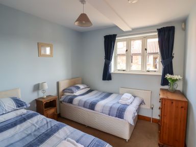 A bedroom with two beds and a window at Wheelwright's Cottage Ipswich
