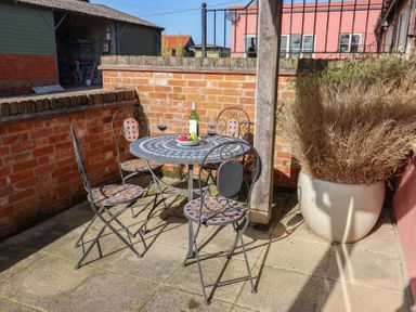 An outdoor seating area with a table and chairs at Wheelwright's Cottage in Ipswich