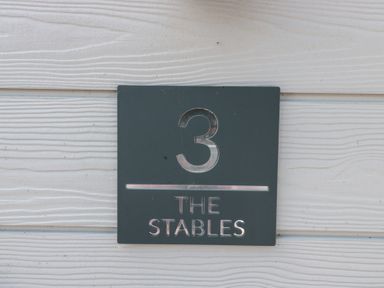 A sign displaying number 3 and The Stables at 3 The Stables Highbridge