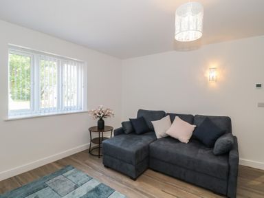 A living room with a sofa and window at 3 The Stables in Highbridge