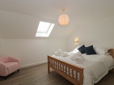 A bedroom with a bed and chair at 3 The Stables Highbridge