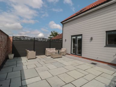 A patio area with seating and a table at 3 The Stables in Highbridge