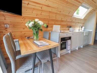 A kitchen with a table and chairs and a television at Pendle in Nelson