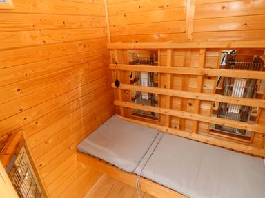 A small room with wooden walls and a mattress at The Tiny House in Nine Wells near Solva
