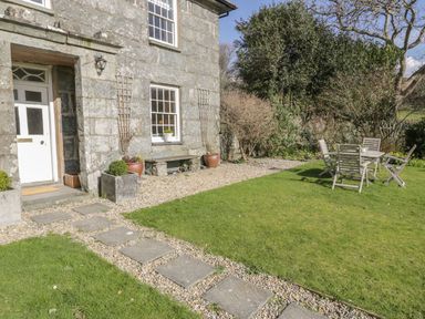 A house entrance with garden furniture at Bwthyn Morse in Llanfair