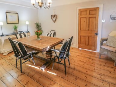 A dining room with a table and chairs at Bwthyn Morse in Llanfair
