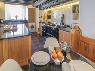 A kitchen with a table and chairs at Bwthyn Morse in Llanfair