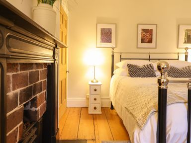 A bedroom with a bed, fireplace and nightstand at Bwthyn Morse Llanfair