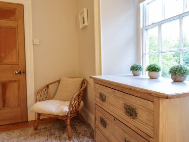 A hallway with a chair and drawers at Bwthyn Morse in Llanfair