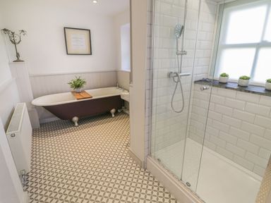 A bathroom featuring a bathtub and shower at Bwthyn Mawr in Llanfair